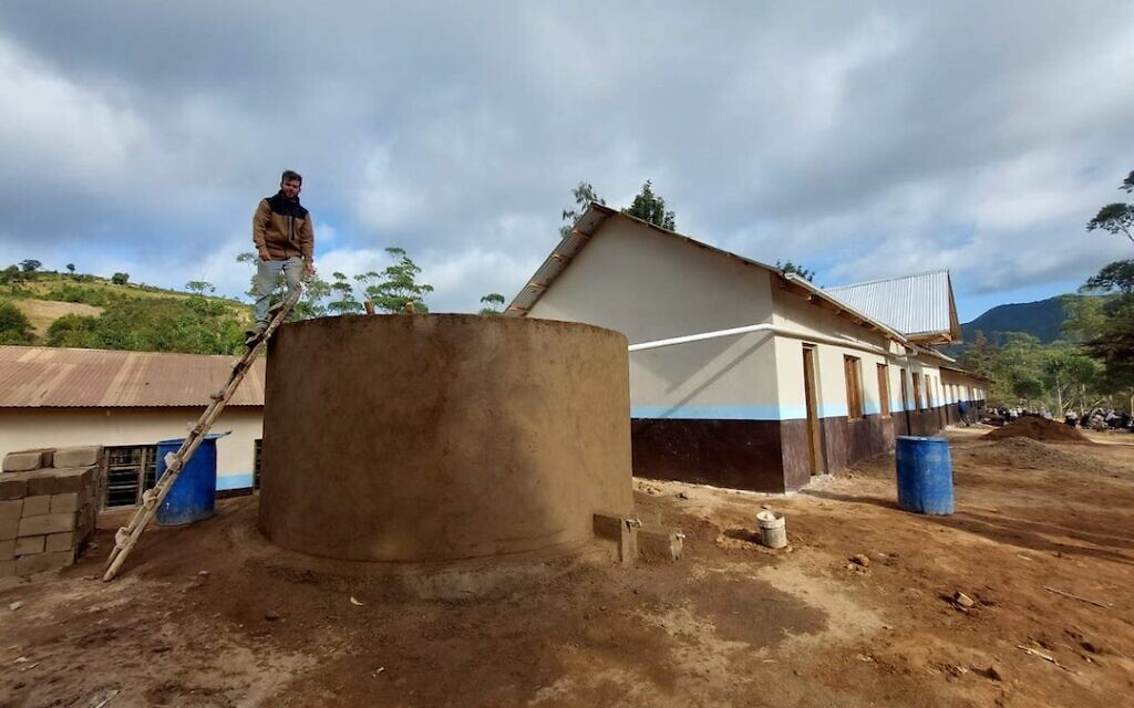 Afrikan member Gal Genossar stands atop water harvesting tank built on roof of school in Malindi, Tanzania. (Courtesy of Afrikan)