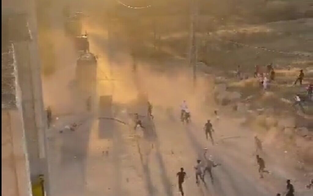 Palestinians throw rocks at Israeli military vehicles near Hebron on July 4, 2022. (Screen capture: Twitter)