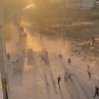 Palestinians throw rocks at Israeli military vehicles near Hebron on July 4, 2022. (Screen capture: Twitter)