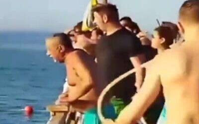 Tourists watch as a woman struggles back to shore after a shark attack in Egypt, July 1, 2022. (Screen grab)
