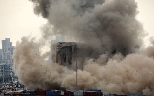 Heavy dust rises as part of the grain silos in the port of Beirut collapse on the 2nd anniversary of a deadly blast which killed over 200 people, August 4, 2022. (Ibrahim Amro/AFP)