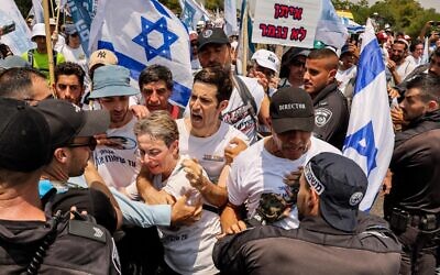 Leah Goldin (C), mother of late Israeli soldier Hadar Goldin whose body has been held by Hamas since the 2014 Gaza conflict, is prevented along with others from proceeding by Israeli police forces in the southern Israeli kibbutz of Karmia on August 5, 2022. (JACK GUEZ / AFP)