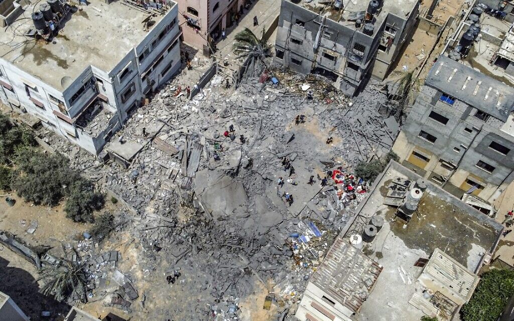 This aerial view shows Palestinians inspecting the ruins of a collapsed building destroyed by an Israeli air strike in Gaza City, on August 6, 2022.  (Mohammed Abed/AFP)