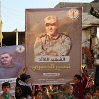 Supporters of the Palestinian Islamic Jihad terror group march with posters depicting senior commanders Khaled Mansour (L) and Tayseer Jabari, who were killed in Israeli strikes on the Gaza Strip, during a rally in Lebanon's refugee camp of Burj al-Barajneh on August 7, 2022. (Anwar Amro/AFP)