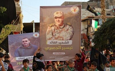 Supporters of the Palestinian Islamic Jihad terror group march with posters depicting senior commanders Khaled Mansour (L) and Tayseer Jabari, who were killed in Israeli strikes on the Gaza Strip, during a rally in Lebanon's refugee camp of Burj al-Barajneh on August 7, 2022. (Anwar Amro/AFP)