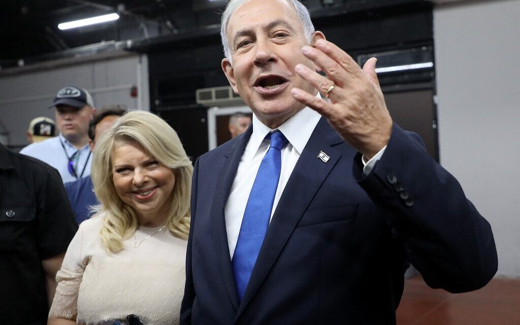 Likud party leader and former prime minister Benjamin Netanyahu gestures after voting next to his wife Sara in a primary to fill out the party's Knesset slate, in Tel Aviv on August 10, 2022. (Gil Cohen-Magen/AFP)