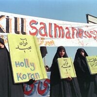 In this file photo taken on February 17, 1989, Iranian women are seen holding banners which read 'Holly Koran' and 'Kill Salman Rushdie' during a demonstration against British writer Salman Rushdie in Tehran. (Norbert Schiller/AFP)