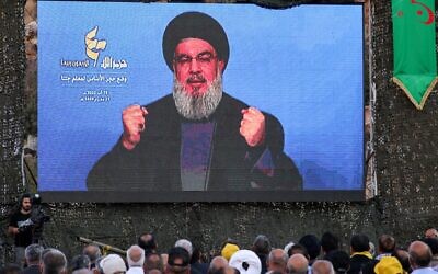 Supporters of Hezbollah attend a televised speech by the Lebanese terror group's leader Hassan Nasrallah during a ceremony to lay the foundation for a site for 'jihadist tourism,' at a camp formerly run by Iran's Islamic Revolutionary Guard Corps in Lebanon to train Hezbollah fighters, in the Janta region in the east of the country on August 19, 2022. (AFP)