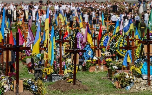 People attend a ceremony for the fallen soldiers of Ukraine at the Lychakiv Cemetery in western Ukrainian city of Lviv on August 24, 2022 (YURIY DYACHYSHYN/AFP)