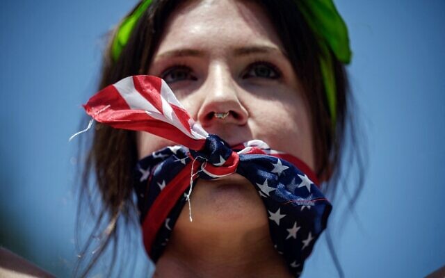 In this file photo taken on July 4, 2022, a reproductive rights activist, gagged by a scarf in the colors of the US flag, marches during a protest against a recent Supreme Court ruling on abortion rights, in New York (Ed Jones/AFP)