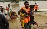 Rescue workers help evacuate flood affected Pakistanis from their flood hit homes following heavy monsoon rains in Rajanpur district of Punjab province on August 27, 2022. (Shahid Saeed Mirza/AFP)