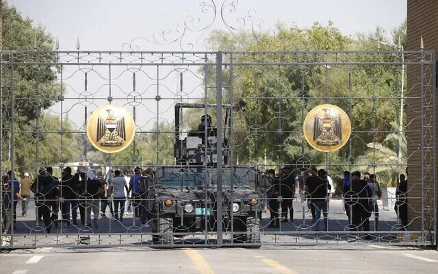 Iraqi police are pictured standing guard at the closed gate of the government headquarters in the capital Baghdad's Green Zone, on August 29, 2022. (Ahmad Al-Rubaye/AFP) Iraqi police are pictured standing guard at the closed gate of the government headquarters in the capital Baghdad's Green Zone, on August 29, 2022. (Ahmad Al-Rubaye/AFP)