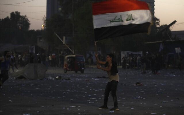 A supporter of Iraqi Shiite cleric Muqtada al-Sadr waves the Iraqi flag in the capital Baghdad, on August 29, 2022. (Ahmad Al-Rubaye/AFP) A supporter of Iraqi Shiite cleric Muqtada al-Sadr waves the Iraqi flag in the capital Baghdad, on August 29, 2022. (Ahmad Al-Rubaye/AFP)