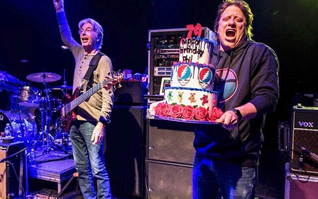 Peter Shapiro, right, brings out a birthday cake to Phil Lesh, who turned 79 on the evening of his 79th performance at the Capitol Theatre. (Jay Blakesberg/ Courtesy)