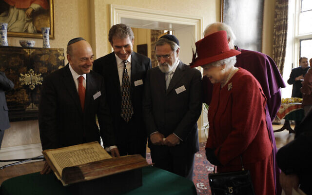 Britain's Queen Elizabeth II, right, is shown the Codex Valmadonna I book by, from left, President of Board of Deputies of British Jews Vivian Wineman, Chairman of Ostro Minerals Schweiz AG Maurice Ostro and UK Chief Rabbi Jonathan Sacks at a reception to mark the Diamond Jubilee in London, February 15, 2012. (AP Photo/Matt Dunham, Pool)