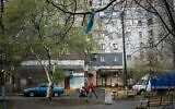 In this photo taken on Monday, April 15, 2019, a woman pushes a stroller near an apartment building in Kryvyi Rih, in eastern Ukraine, where presidential candidate Volodymyr Zelenskiy once lived. (AP/Evgeniy Maloletka)