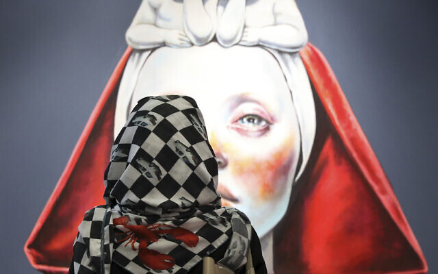 A woman looks at a painting as she visits the Teer Art fair at Charsou complex in Tehran, Iran, Tuesday, June 25, 2019. (AP/Vahid Salemi)