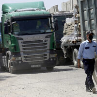 Illustrative: A Hamas security officer checks trucks carrying materials that are waiting to enter Gaza, at the Kerem Shalom cargo crossing with Israel, in Rafah, southern Gaza Strip, September 1, 2021. (AP Photo/Adel Hana)