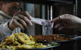 Illustrative: A man buys food at a popular restaurant in Cairo, Egypt, March 22, 2022. (AP/Amr Nabil)