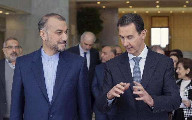 In this photo released by the Syrian official news agency SANA, Syrian President Bashar Assad, right, speaks with Iran's Foreign Minister Hossein Amir-Abdollahian on March 23, 2022, in Damascus, Syria. (SANA via AP)