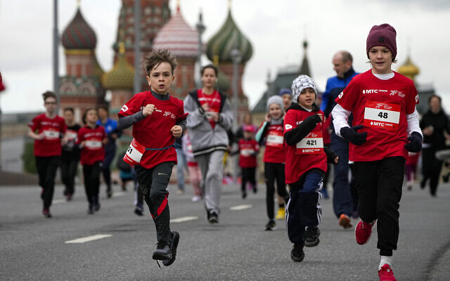 Illustrative: Children run over the Bolshoy Moskvoretsky Bridge over the Moskva River while taking part in the 'Running Hearts' Charity Race with St. Basil's Cathedral in the background, in Moscow, Russia, May 28, 2022. (AP Photo/Alexander Zemlianichenko)