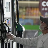 Illustrative: A driver looks at the pump at a gas station in London, June 9, 2022. (AP Photo/Frank Augstein, File)