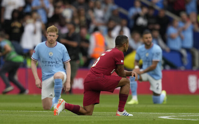 Liverpool's Thiago, centre, and Manchester City's Kevin De Bruyne take a knee before the FA Community Shield soccer match between Liverpool and Manchester City at the King Power Stadium in Leicester, England, Saturday, July 30, 2022. (AP Photo/Frank Augstein)