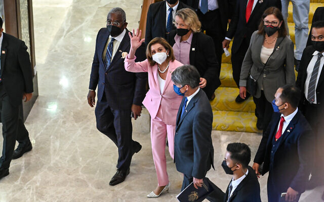 This handout photo taken and released by Malaysia’s Department of Information, US House Speaker Nancy Pelosi, center, waves to media as she tours the parliament house in Kuala Lumpur, Tuesday, Aug. 2, 2022. (Malaysia’s Department of Information via AP)