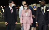 US House Speaker Nancy Pelosi, center, walks with Taiwan's Foreign Minister Joseph Wu, left, as she arrives in Taipei, Taiwan, Aug. 2, 2022.  (Taiwan Ministry of Foreign Affairs via AP)
