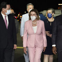 US House Speaker Nancy Pelosi, center, walks with Taiwan's Foreign Minister Joseph Wu, left, as she arrives in Taipei, Taiwan, Aug. 2, 2022.  (Taiwan Ministry of Foreign Affairs via AP)
