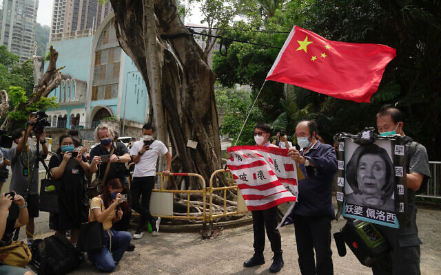 Pro-China supporters hold U.S. flag and a picture of US House Speaker Nancy Pelosi during a protest outside the Consulate General of the United States in Hong Kong, Wednesday, Aug. 3, 2022. U.S. (AP Photo/Kin Cheung)