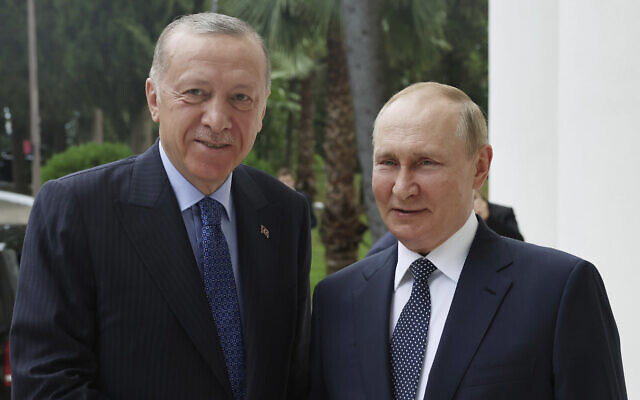 In this handout photo provided by the Turkish Presidency, Turkish President Recep Tayyip Erdogan, left, and Russian President Vladimir Putin shake hands prior to their meeting at the Rus sanatorium in the Black Sea resort of Sochi, Russia, August 5, 2022. (Turkish Presidency via AP)