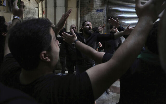 Mourners strike their chests during a procession commemorating the holiday of Ashoura, which marks the death anniversary of Imam Hussein, the grandson of Prophet Muhammad, who was killed with 72 of his companions in the 7th century in the Battle of Karbala in present-day Iraq, in Tehran, Iran, on August 8, 2022. (Vahid Salemi/AP)