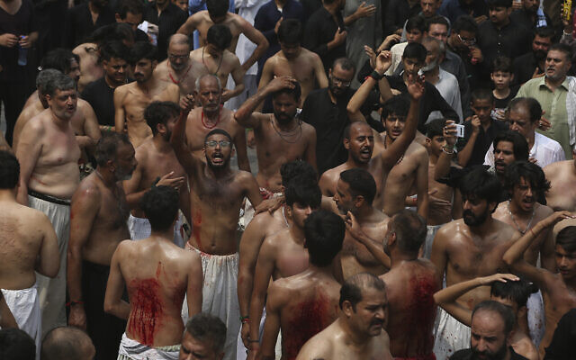 Shiite Muslims flagellate themselves with knives on chains during a procession, in Peshawar, Pakistan, in honor of the holiday of Ashoura on August 8, 2022. (Muhammad Sajjad/AP)