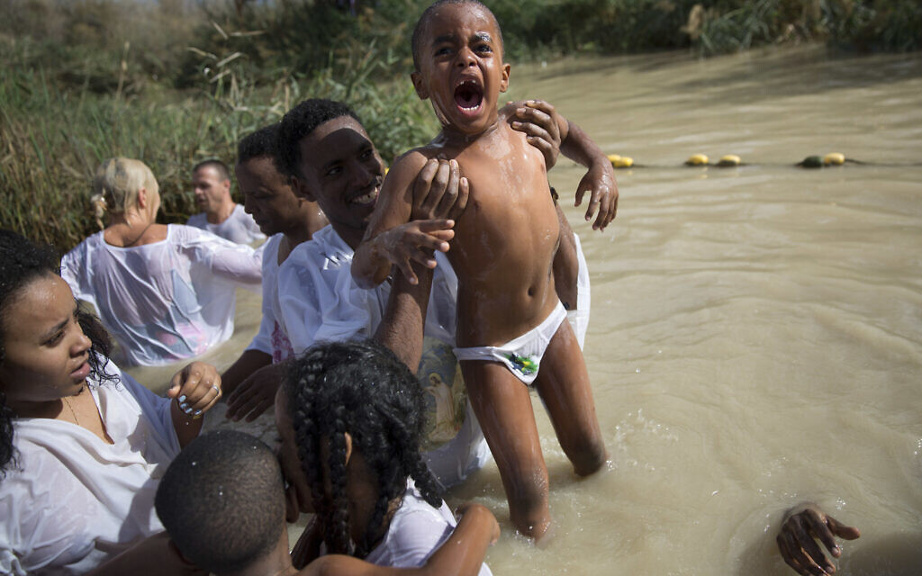 Members of the Eritrean and Ethiopian Christian Orthodox community from Tel Aviv stand in the waters of the Jordan River during a baptism ceremony as part of the Orthodox Feast of the Epiphany at the Qasr al-Yahud baptismal site, near the West Bank town of Jericho on Friday, Jan. 19, 2018. (Oded Balilty/AP)