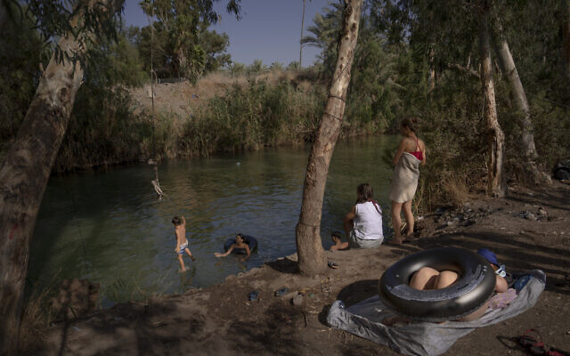 People spend the day at the Jordan River near Kibbutz Kinneret in northern Israel, July 30, 2022. (Oded Balilty/AP)