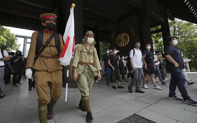 Visitors in old Japanese Imperial army uniforms enter Yasukuni Shrine, which honors Japan's war dead, August 15, 2022, in Tokyo. (AP Photo/Eugene Hoshiko)