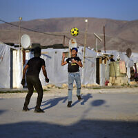 Syrian children play soccer near their tented homes at a refugee camp in the town of Bar Elias, in the Bekaa Valley, Lebanon, July 7, 2022. (AP Photo/ Bilal Hussein, File)