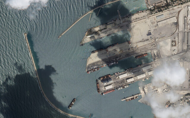 This satellite image from Planet Labs PBC shows the Sierra Leone-flagged cargo ship Razoni, center bottom with four white cranes on its red deck, at port in Tartus, Syria, Monday, Aug. 15, 2022. (Planet Labs PBC via AP)