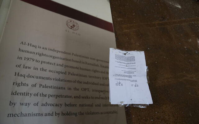 An Israeli army closure order hangs on the door of the sealed office of the al-Haq human rights organization that was raided by Israel in Ramallah, August 18, 2022. (AP/Nasser Nasser)