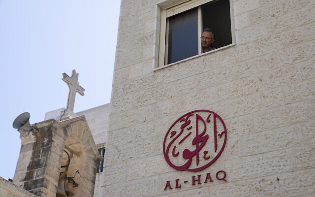 A man looks out of the window of the office of al-Haq Human rights organization that is adjacent to the St. Andrew's Anglican Episcopal Church, in the West Bank city of Ramallah, August 18, 2022. (AP Photo/Nasser Nasser)