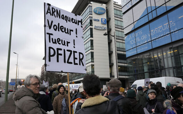 Illustrative: A demonstrator holds a placard reading 'Scammer, thief, killer, Pfizer' during a protest against the vaccine pass and vaccinations to protect against COVID-19 in front of the Pfizer headquarters, in Paris, on January 29, 2022. (AP Photo/Thibault Camus, File)