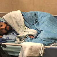 Khalil Awawdeh lies in bed at Asaf Harofeh Hospital in Be'er Ya'akov on August 19, 2022. (Ahlam Haddad, via AP)
