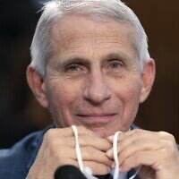 Dr. Anthony Fauci holds his face mask in his hands, as he attends a House Committee on Appropriations subcommittee hearing on about the budget request for the National Institutes of Health, May 11, 2022, on Capitol Hill in Washington. (AP/Jacquelyn Martin)