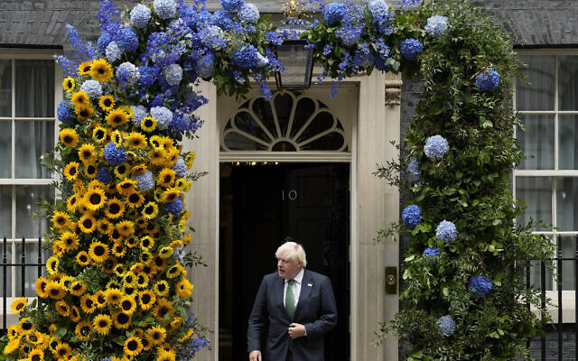 Britains Prime Minister Boris Johnson leaves 10 Downing Street to look at the flower decoration in the national Ukrainian colours one day ahead of the Independence Day of Ukraine in London, Tuesday, Aug. 23, 2022. (AP Photo/Frank Augstein)