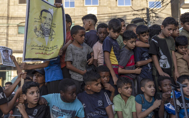 Children hold a photo of Islamic Jihad commander Khaled Mansour, who was killed in an Israeli airstrike, as Palestinian Islamic Jihad members take part in an anti-Israel rally in Rafah, south of Gaza City, Aug. 24, 2022. (Fatima Shbair/AP)