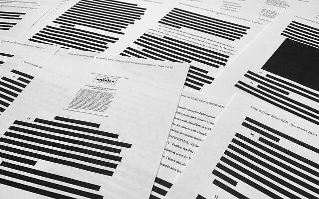 Pages from the affidavit by the FBI in support of obtaining a search warrant for former President Donald Trump's Mar-a-Lago estate are photographed Friday, August 26, 2022. (AP Photo/Jon Elswick)