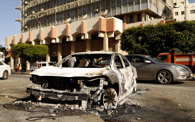 The remains of a car damaged in deadly clashes between militias backed by two rival administrations in the Libyan capital of Tripoli, August 28 2022. (AP/Yousef Murad)
