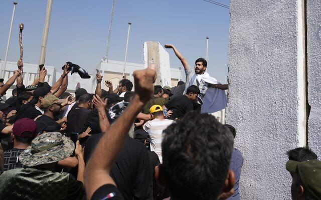 Supporters of Shiite cleric Muqtada al-Sadr try to remove concrete barriers in the Green Zone area of Baghdad, Iraq, August 29, 2022. (AP Photo/Hadi Mizban) Supporters of Shiite cleric Muqtada al-Sadr try to remove concrete barriers in the Green Zone area of Baghdad, Iraq, August 29, 2022. (AP Photo/Hadi Mizban)