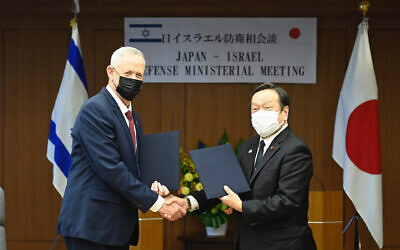 Defense Minister Benny Gantz (left) and Japan's Defense Minister Yasukazu Hamada  shake hands during a signing of the Japan-Israel defense exchange memorandum of understanding after their bilateral meeting at the Defense Ministry in Tokyo, August 30, 2022. (David Mareuil/Pool Photo via AP)